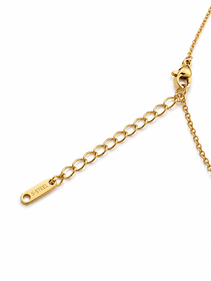 Close-up of a gold chain extender with a lobster clasp and a small engraved tag reading S.STEEL, shown on a plain white background.