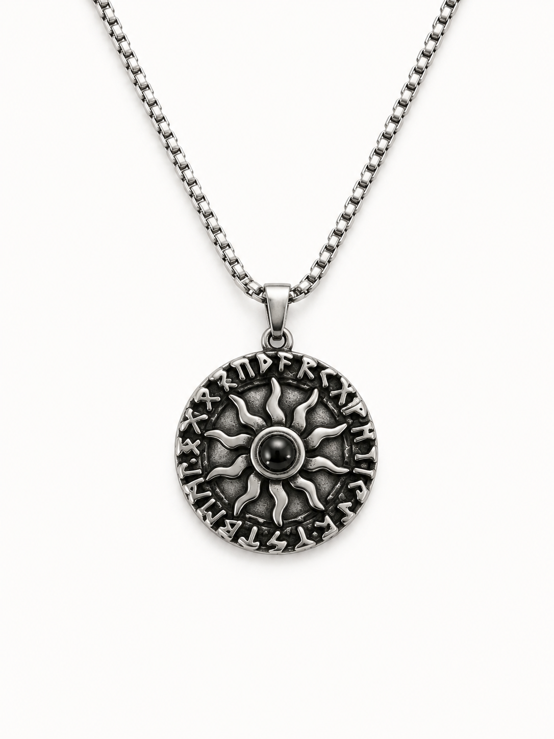 A silver-toned necklace featuring a circular pendant with an embossed sunburst design and raised lettering around the edge, suspended from a matching box chain against a plain white background.