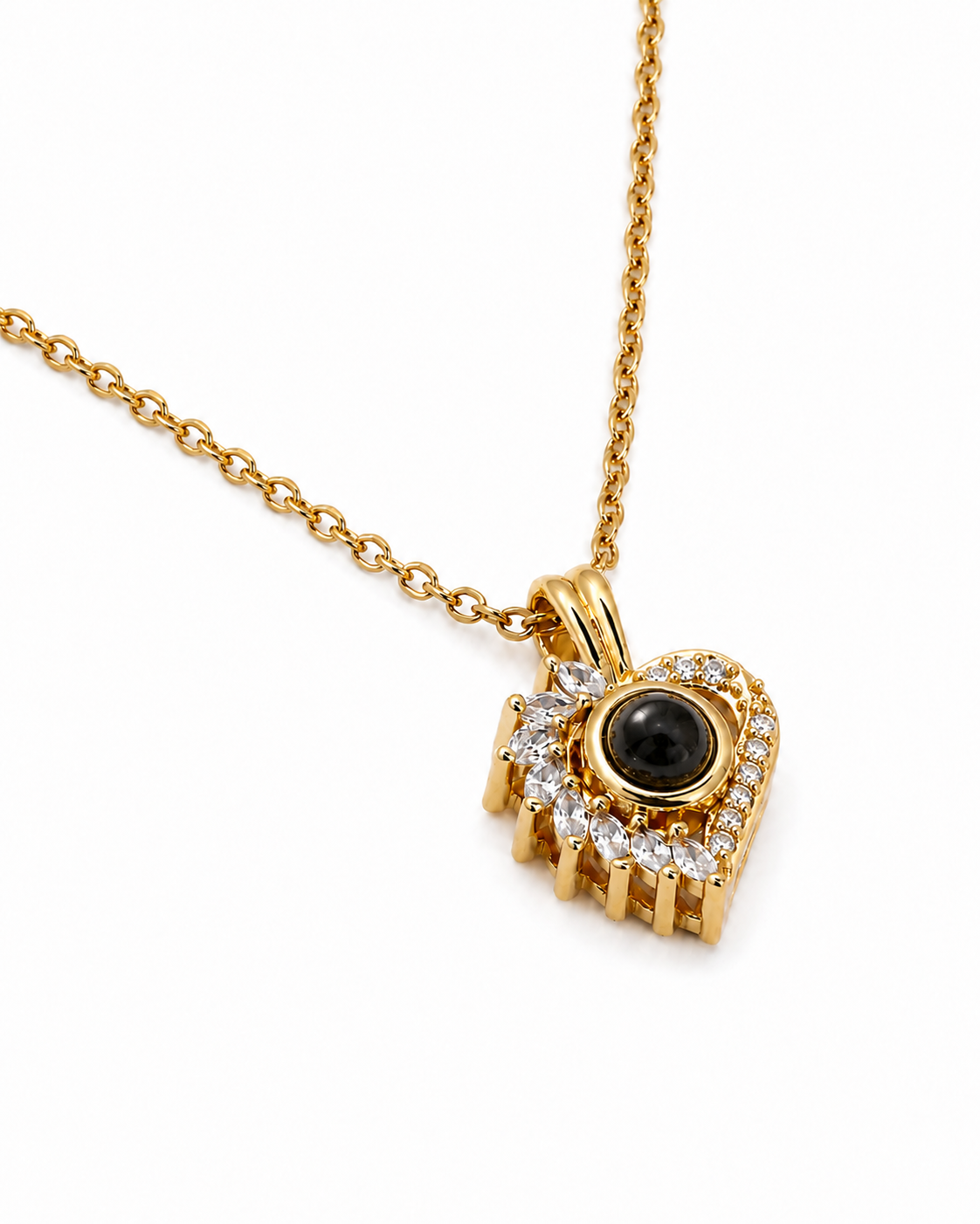 A gold pendant necklace (Jewellery piece) heart shape featuring diamantés all around with a central round black stone, shown on a white background. 
