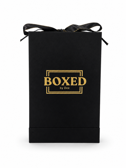 A black gift box with a black ribbon bow on top, featuring the gold foil text 'BOXED by Dee' in the center, set against a plain white background.