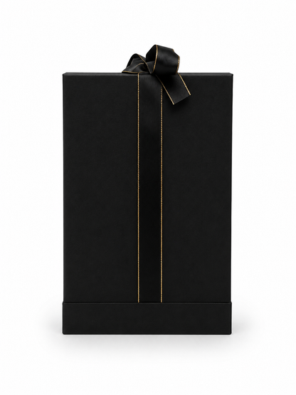 A tall, black rectangular gift box with a black satin ribbon tied in a bow at the top and thin gold vertical stripe details, shown on a plain white background.